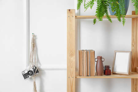 Shelf unit with books and decor near white wall in room