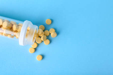Bottle with folic acid pills on color backgroundの写真素材