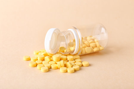 Bottle with folic acid pills on color backgroundの写真素材