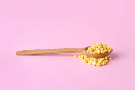 Spoon with folic acid pills on color backgroundの写真素材