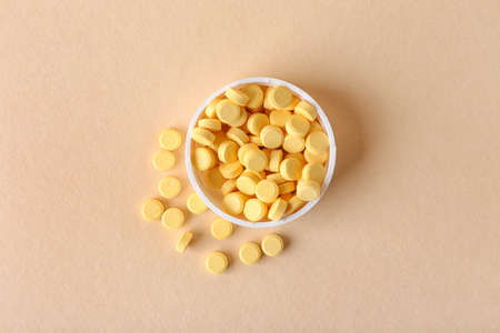 Bowl with folic acid pills on color backgroundの写真素材