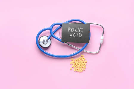 Stethoscope, text FOLIC ACID and pills on color backgroundの写真素材