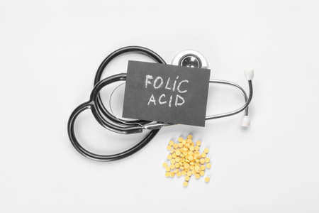 Stethoscope, text FOLIC ACID and pills on white backgroundの写真素材