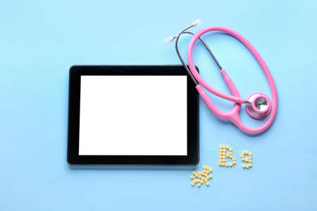 Stethoscope and text B9 made of folic acid pills on color background