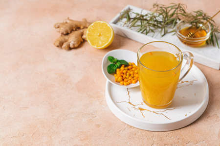 Cup of healthy sea buckthorn tea on color backgroundの写真素材