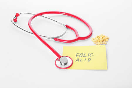 Stethoscope, text FOLIC ACID and pills on white backgroundの写真素材