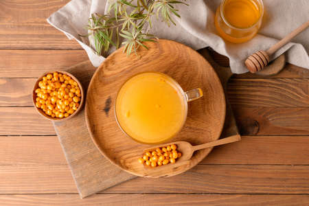 Cup of healthy sea buckthorn tea on table