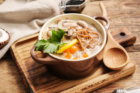 Cooking pot with Thai noodle soup on wooden backgroundの写真素材