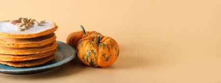 Tasty pumpkin pancakes on color background with space for textの写真素材