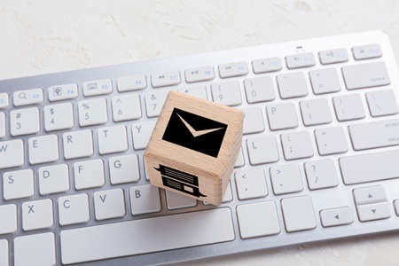 Cube with digital technology icons and computer keyboard on white backgroundの写真素材