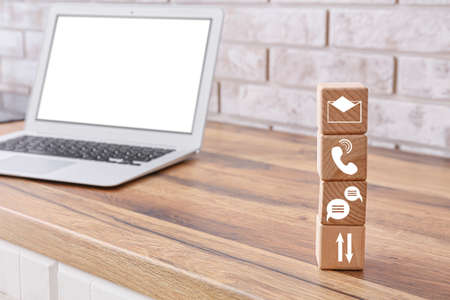 Cubes with digital technology icons and laptop on tableの写真素材