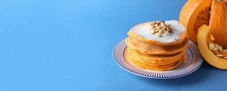 Tasty pumpkin pancakes on color background with space for textの写真素材