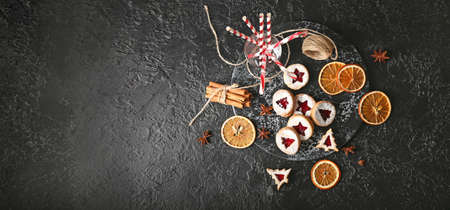 Tasty Linzer cookies with spices and candy canes on dark background with space for textの写真素材