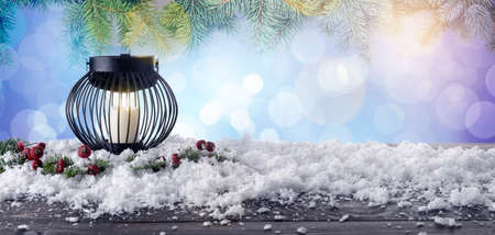 Lantern with snow and fir tree branches on color background with space for text
