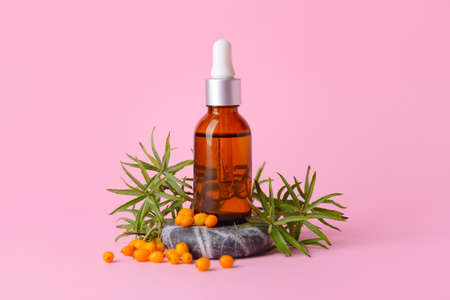 Bottle of healthy sea buckthorn oil on color backgroundの写真素材