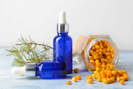 Bottles of healthy sea buckthorn oil on tableの写真素材