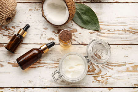 Coconut oil and cosmetics on light wooden backgroundの写真素材