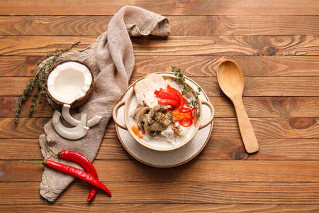 Cooking pot with Thai chicken rice soup on wooden backgroundの写真素材