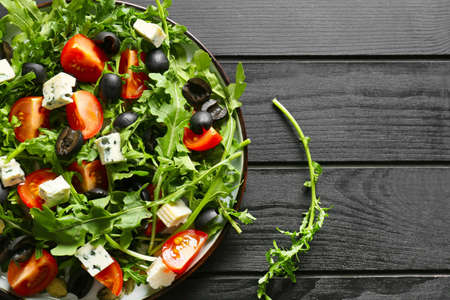 Plate with arugula salad on black wooden backgroundの写真素材