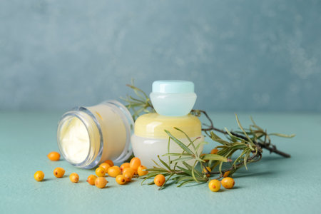 Jars of healthy sea buckthorn cream on color backgroundの写真素材