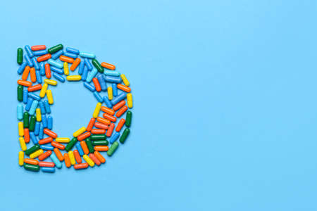 Letter D made of pills on color backgroundの写真素材