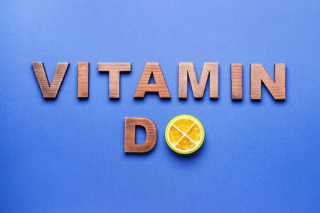 Text VITAMIN D with pills on color backgroundの写真素材