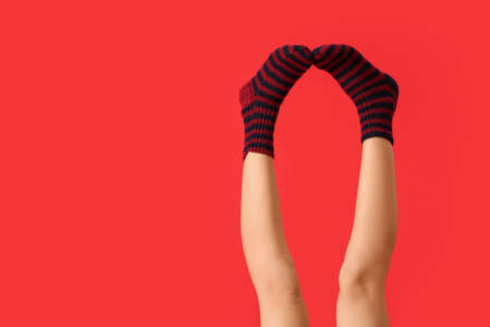 Legs of young woman in socks on color backgroundの写真素材