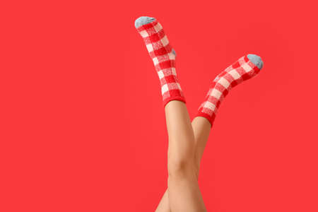 Legs of young woman in socks on color backgroundの写真素材