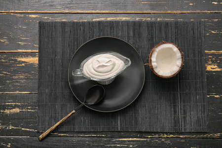 Gravy boat with coconut cream on dark wooden backgroundの写真素材
