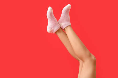 Legs of young woman in socks on color backgroundの写真素材