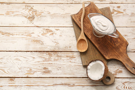 Gravy boat with coconut cream on light wooden backgroundの写真素材