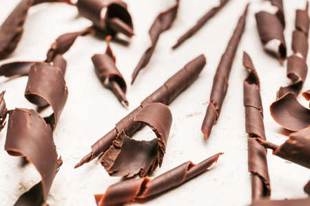 Delicious chocolate curls on light background