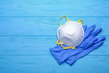 Respirator and protective gloves on color wooden backgroundの写真素材