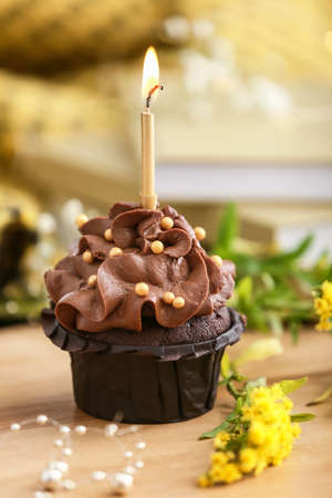 Tasty chocolate cupcake with candle on table