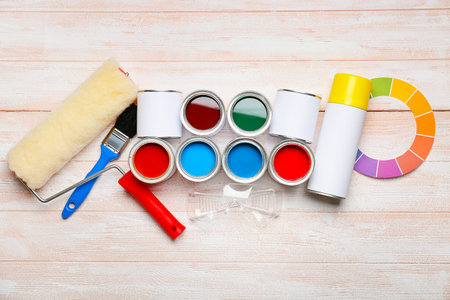 Cans of paints and tools on color wooden backgroundの写真素材