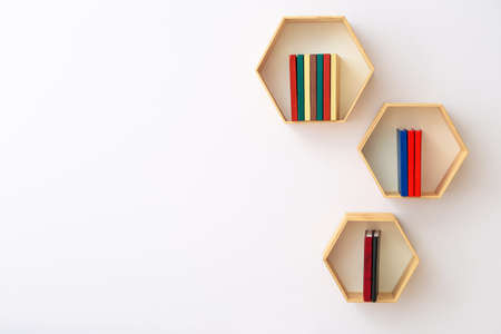 Shelves with books hanging on light wallの写真素材