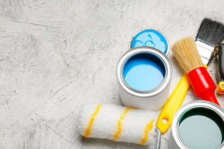 Cans of paints with brushes and roller on light backgroundの写真素材