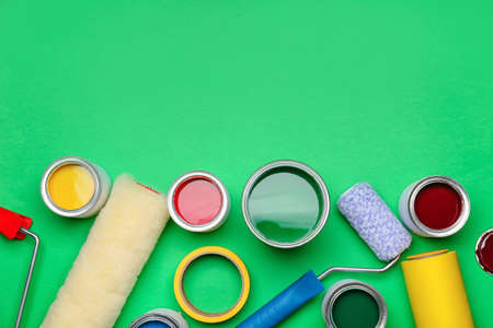 Cans of paints and rollers on color backgroundの写真素材