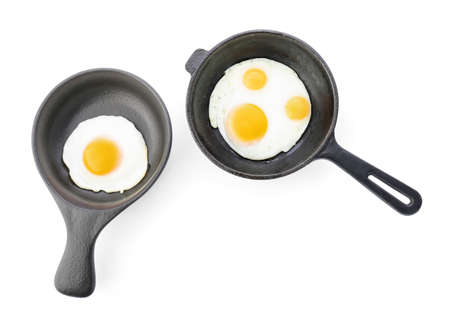 Pans with tasty fried eggs on white backgroundの写真素材