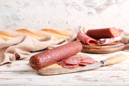 Tasty salami on light wooden background