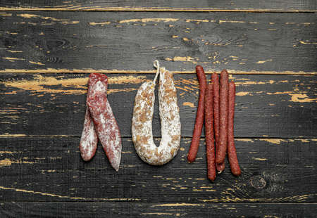 Different sausages on dark wooden background