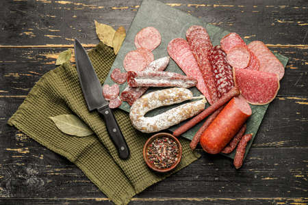 Board with different sausages on wooden backgroundの写真素材