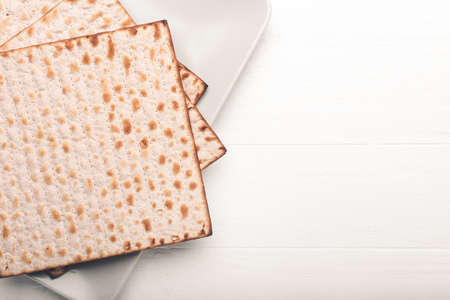 Plate with Jewish flatbread matza for Passover on white wooden backgroundの写真素材
