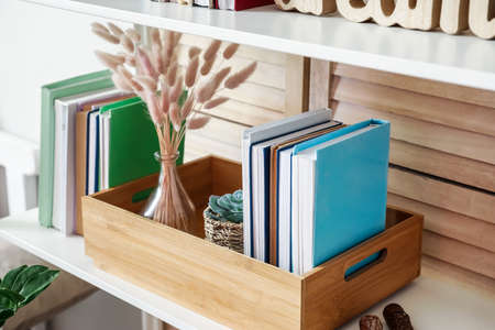 Shelf unit with books and decor in interior of room, closeup