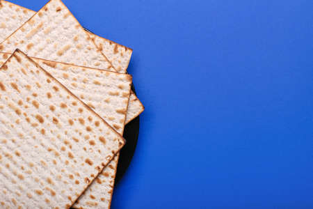 Plate with Jewish flatbread matza for Passover on color background