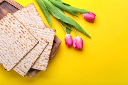 Jewish flatbread matza for Passover and flowers on color backgroundの写真素材