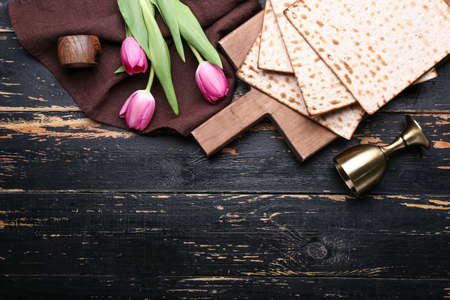 Composition with Jewish flatbread matza for Passover and flowers on dark backgroundの写真素材