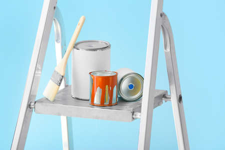 Ladder and cans of paints with brush on color background, closeupの写真素材