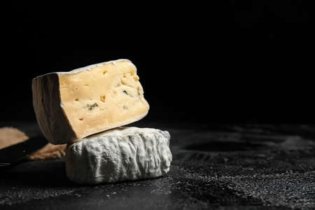Pieces of tasty cheese on dark background, closeupの写真素材