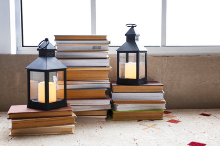 Stack of books with lanterns near window in roomの写真素材